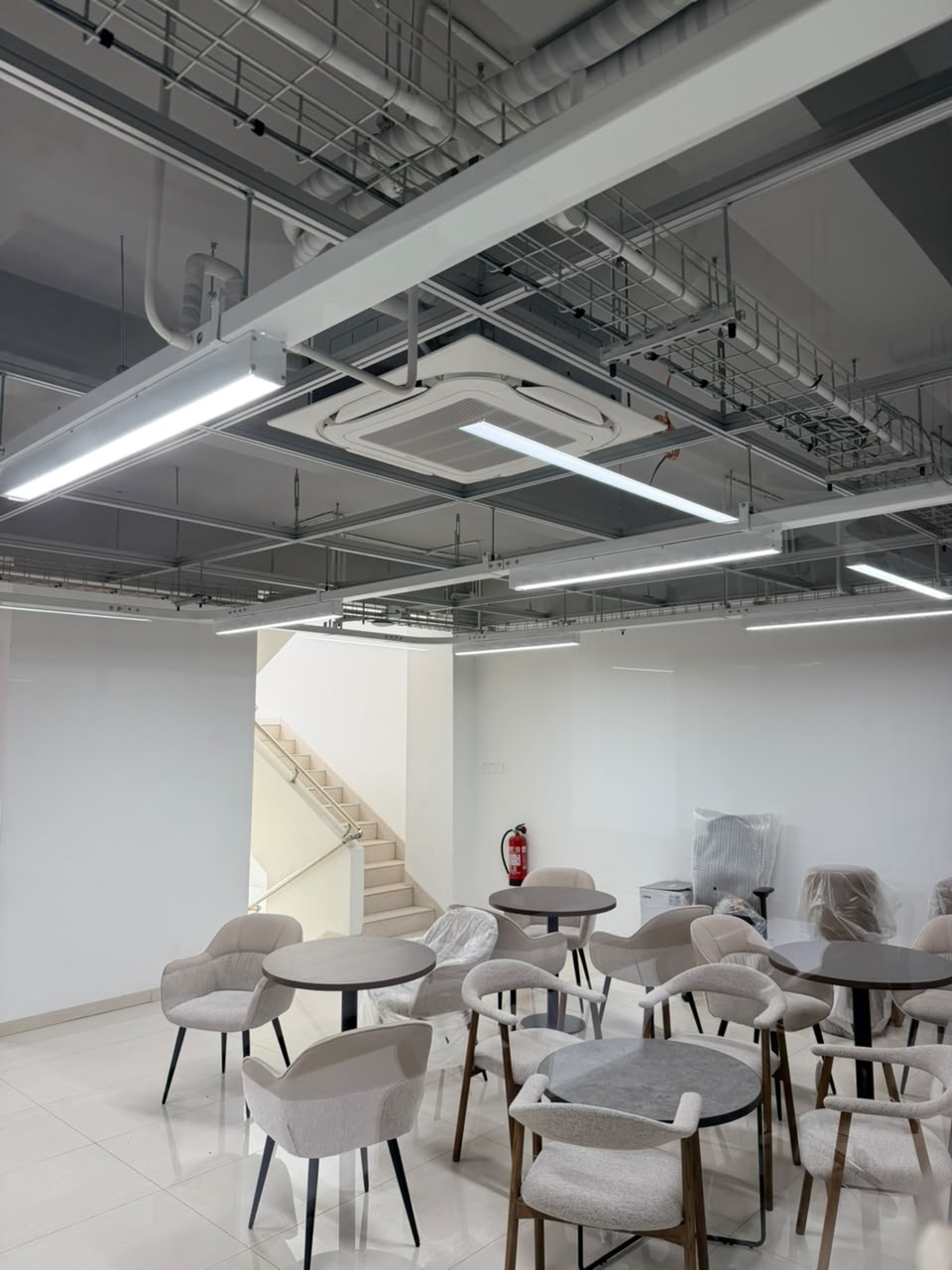 Area lounge kantor dengan pencahayaan linear